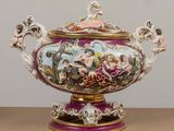 un grand vase avec un tableau posé sur une table