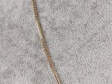 a gold necklace with a bar on a chain