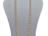 a white mannequin with a pearl necklace on it