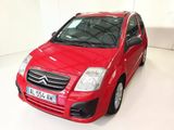 une voiture rouge garée dans une pièce blanche