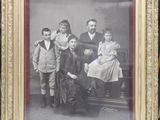 an old photo of a family posing for a picture in a gold frame