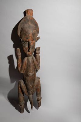an old wooden statue of a man holding a knife in his hand
