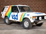 a white van with a rainbow painted on it parked in front of a brick wall