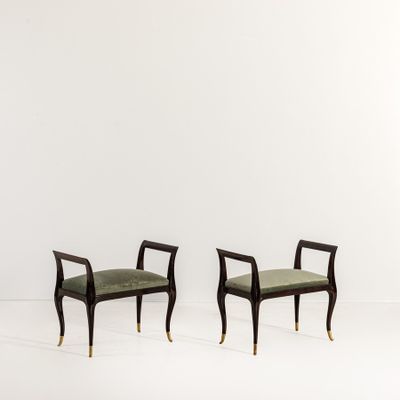a pair of black and gold chairs with green upholstered cushions