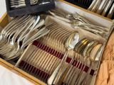 a wooden box with silverware in it on a table