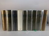 several books are lined up in a row on a table