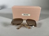 sunglasses in a box on a table with a pair of scissors