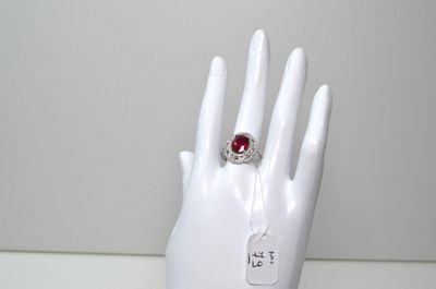 une main de mannequin blanche ornée d'une bague rouge