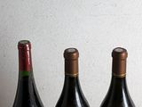 three bottles of wine sitting on a table next to each other