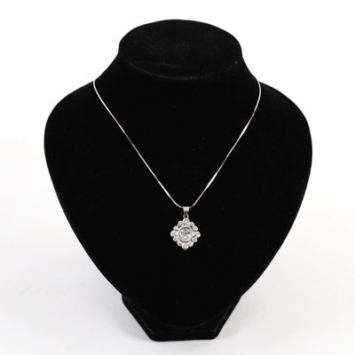 silver plated necklace with a flower pendant on a black mannequin
