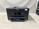 a printer sitting on top of a counter next to a shelf