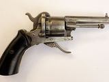 gros plan d'un revolver sur une surface blanche