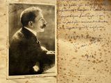 an old photo of a man in a suit and tie sitting in front of a book