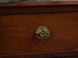 a close up of a wooden dresser with a marble top