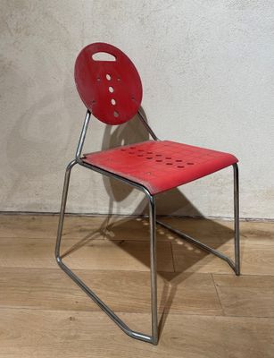 une chaise rouge posée sur un parquet en bois dur