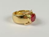 a close up of a gold ring with a red stone in it
