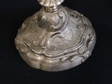 a silver object on a black surface with a black background