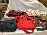 de nombreux sacs et sacs à main posés sur une table dans une pièce