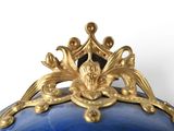 a blue vase with a gold decoration on it