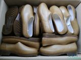 plusieurs paires de chaussures dans une boîte posée sur le sol