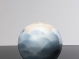 a blue and white vase sitting on a black table