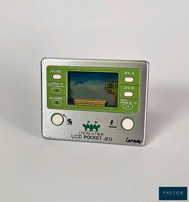 a silver and green electronic device sitting on a white surface