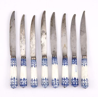 four knives are lined up in a row on a white surface