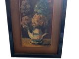 tableau représentant des fleurs dans un vase posé sur une table, dans un cadre noir