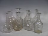 six clear glass bottles are lined up on a white surface