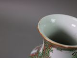 a vase that has a green and red design on it