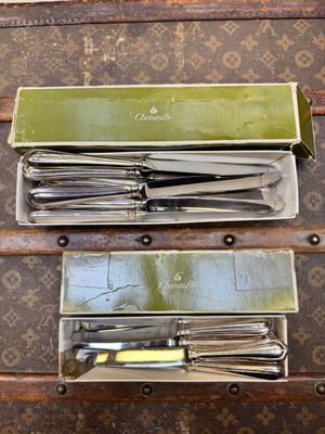 beaucoup de couteaux dans une boîte posée sur une table