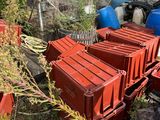 a pile of red crates sitting in the grass