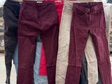 trois paires de pantalons suspendues à un portant devant un entrepôt