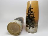 two vases with trees on them sitting next to each other