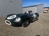 une voiture de course verte garée devant un immeuble