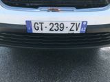 a white car with a blue license plate on the front of it