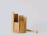 a wooden toothbrush holder that has a toothbrush in it