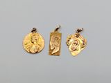 three gold pendants with a picture of a woman and a man on them