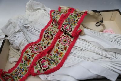 a white shirt and a pink scarf in a suitcase