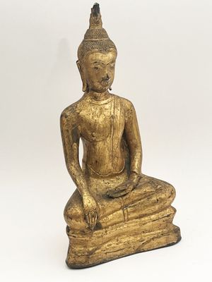 statue d'un Bouddha assis sur un livre, sur fond blanc