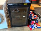 a small refrigerator and a washing machine in a room