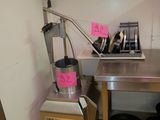 une cuisine équipée d'un évier et d'un plan de travail sur lequel sont posées des casseroles et des poêles