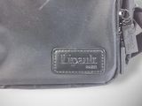 a grey bag that has a leather label on it