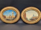 two framed paintings of a city and a boat on a body of water