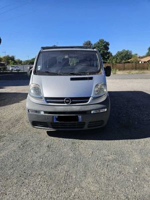 une photo d'une camionnette argentée garée sur un parking