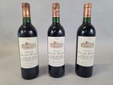 trois bouteilles de vin posées sur une table l'une à côté de l'autre