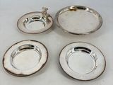 trois plats en métal argenté et une assiette en argent sur un fond blanc