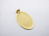 a close up of a gold plated pendant on a white surface