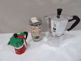 une cafetière et une canette de soda posées sur une table