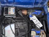 une boîte à outils bleue avec des outils sur le sol